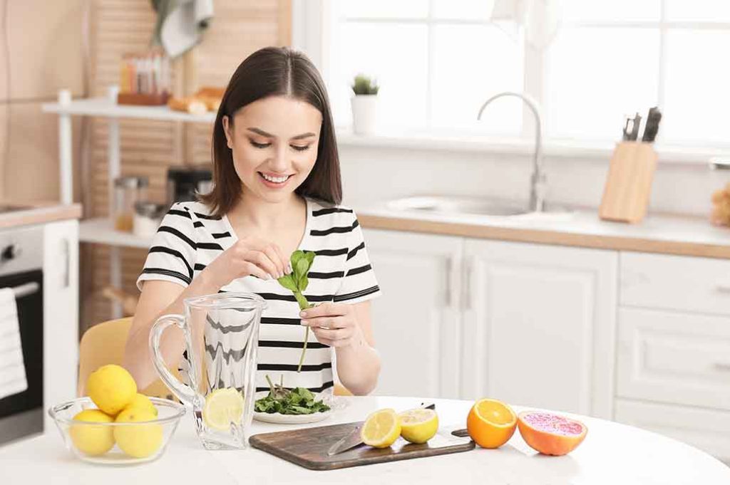 mujer en la cocina preparando aguas con sabor