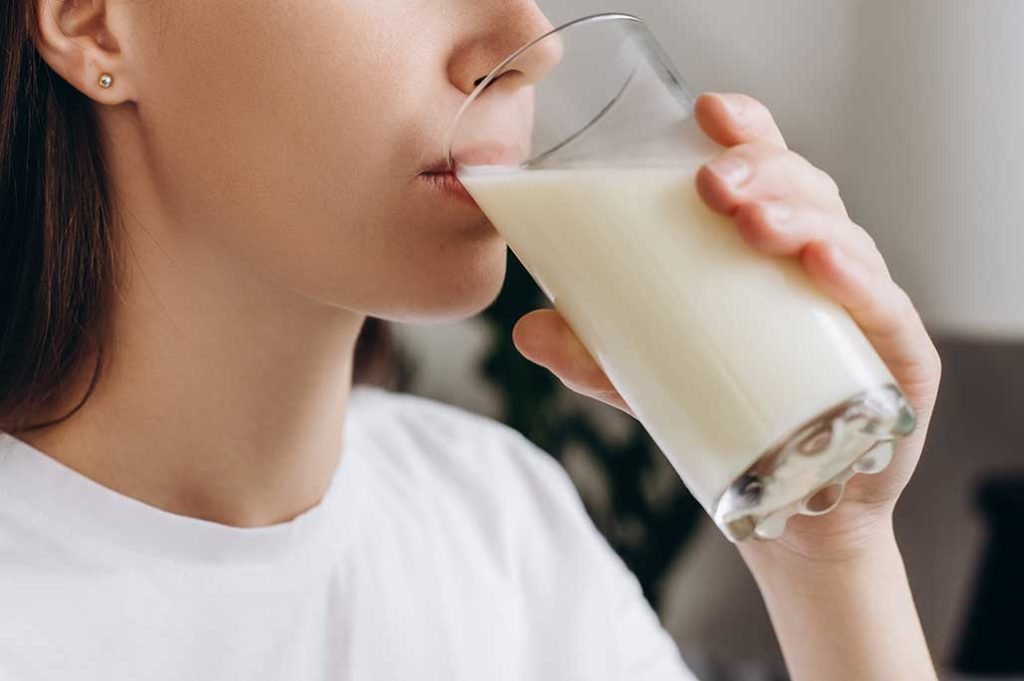 mujer tomando vaso de leche