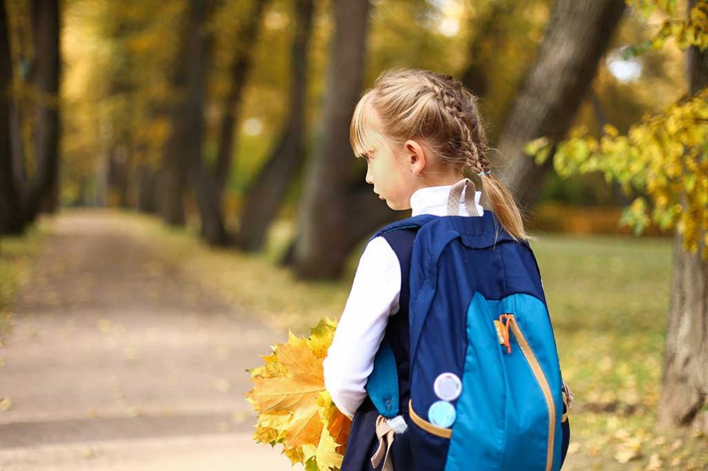 niña con uniforme y mochila de colegio