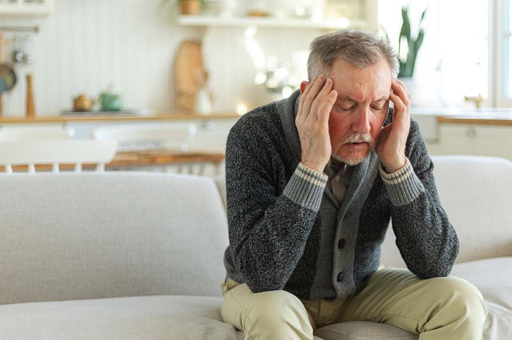 hombre adulto mayor con dolor de cabeza