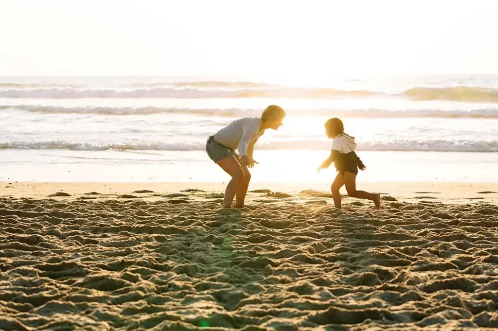 papá e hija en la playa jugando